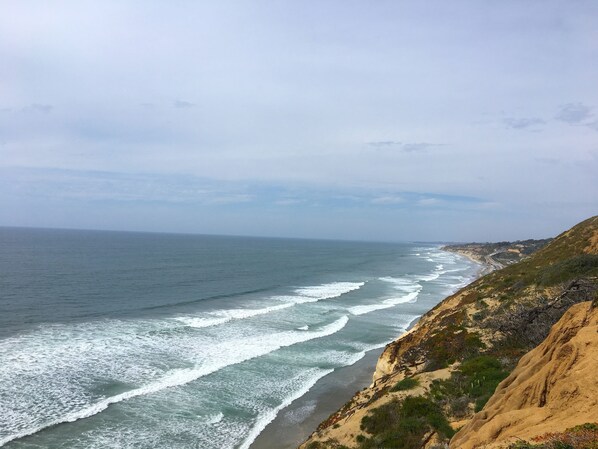 Ranta lähistöllä, aurinkotuoleja, rantapyyhkeitä