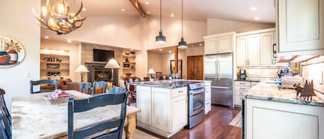 A spacious kitchen with a central island, wooden cabinets, and modern appliances.