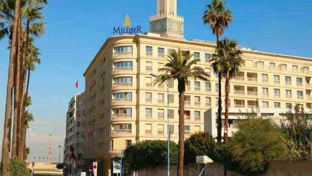 A large, multi-story hotel with a prominent tower and a sign reading "MELTIBER." - Large apartment Casablanca corniche (Casablanca)