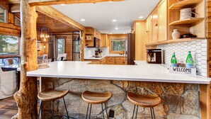 Une cuisine rustique avec des meubles en bois, un plan de travail en pierre et un panneau d’accueil.