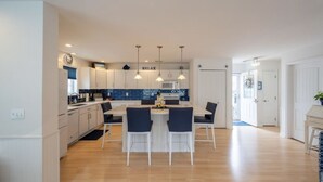 A modern kitchen with white cabinets, a blue backsplash, and pendant lighting. - Beautiful Lavallette Home - Perfect for Family and Friends (Lavallette)