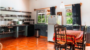Una cocina compacta con zona de comedor, refrigerador, microondas y lavaplatos.