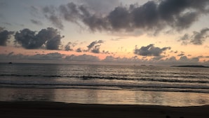 Una playa con olas y un atardecer.