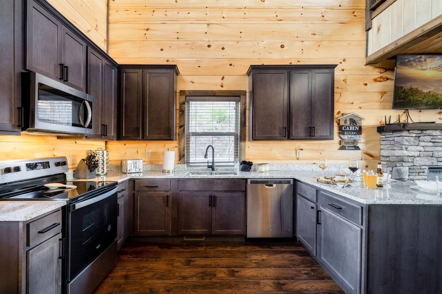 Una cocina moderna con armarios de madera oscura, electrodomésticos de acero inoxidable y una chimenea de piedra.
