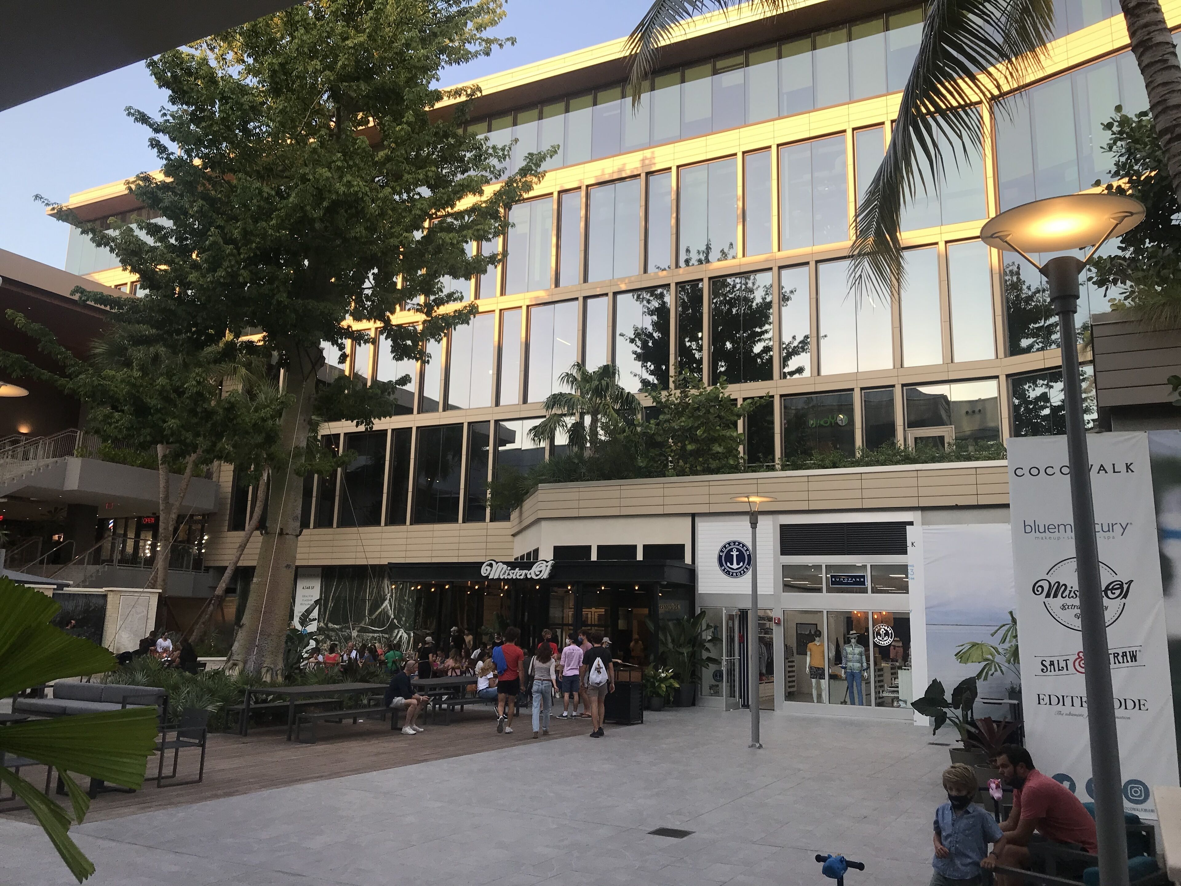 Un edificio moderno con amplios ventanales y un café llamado 'Mister O' en la planta baja.
