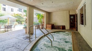 A spa area with a hot tub, outdoor seating, and a view of the surrounding buildings.