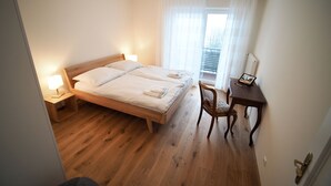 Une chambre à coucher avec un lit en bois, des lampes de chevet, un bureau et une chaise.
