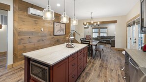 A modern kitchen with wooden accents, a dining area, and a living room.