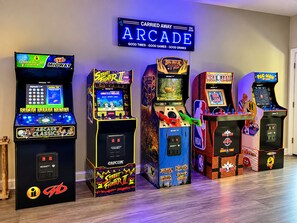 Een rij spelautomaten in een ruimte, met een neonreclame erboven.