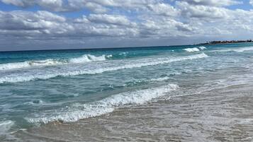 Na praia, espreguiçadeiras, toalhas de praia