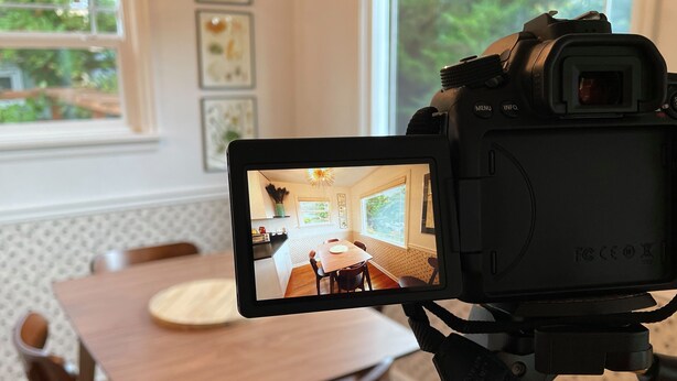 Una cámara mostrando una habitación con una mesa de comedor, sillas y una ventana.