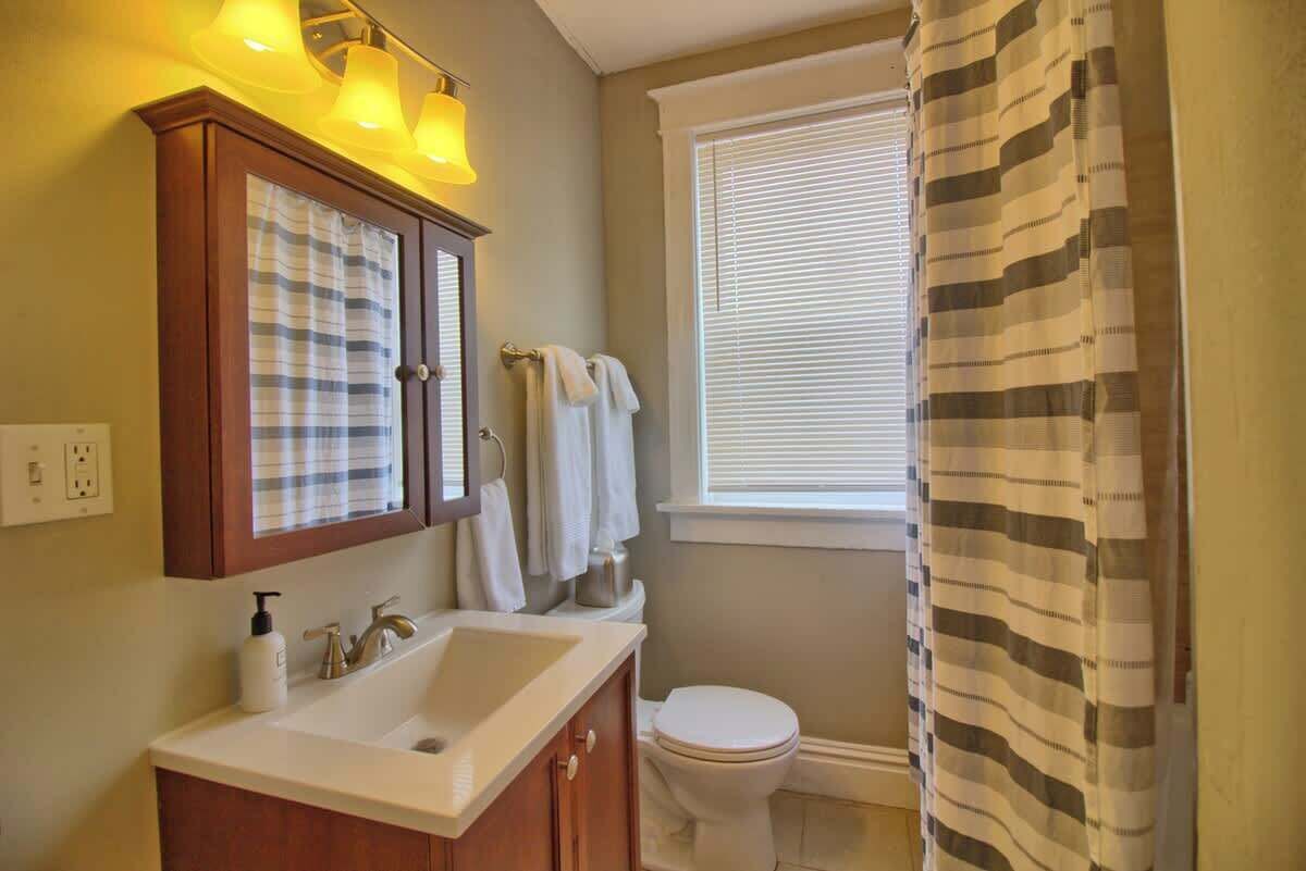 Un bagno con lavandino, specchio e servizi igienici.