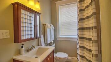 Un bagno con lavandino, specchio e servizi igienici.