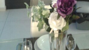 A modern kitchen with a built-in oven, microwave, and sink. There is a vase with flowers on the counter. - Water Front Flat - balcony (Tas-Sliema)