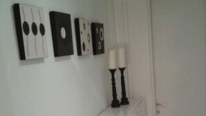 A white room with a long counter, a door, and wall-mounted artwork. - Water Front Flat - balcony (Tas-Sliema)