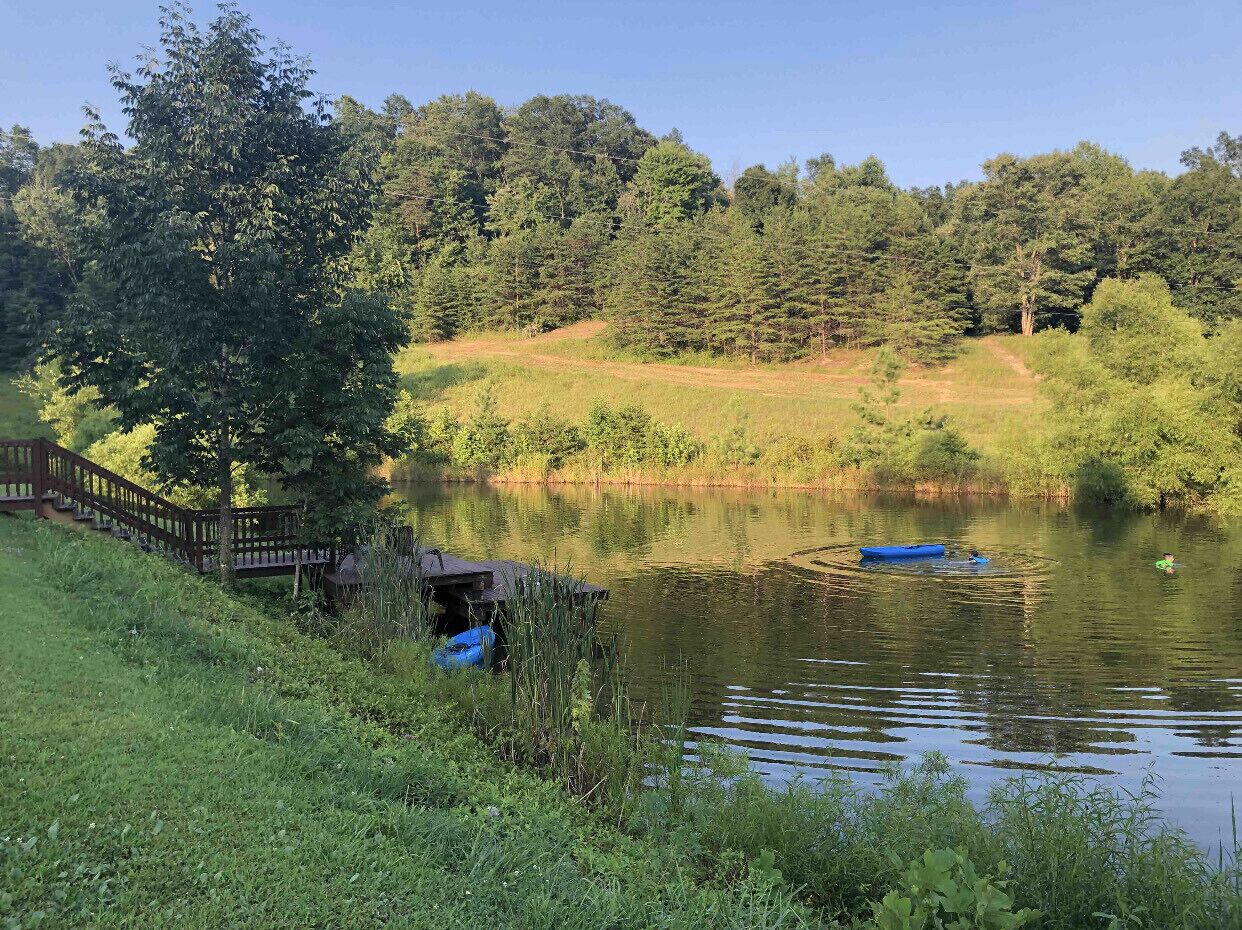 Eine friedliche Seenlandschaft mit einer Holzbrücke und Booten auf dem Wasser.