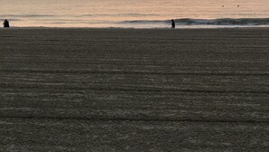 A beach with a sunset in the background. - Captain’s Suite Beach Condo Near Rudee Inlet (Virginia Beach)