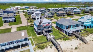 A coastal residential area with multiple two-story houses, some with balconies and a beach access walkway.