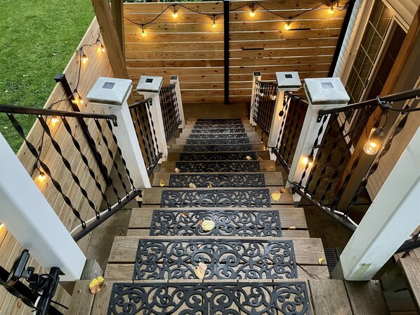 Eine Holztreppe mit verzierten Metallgeländern und Lichterketten.