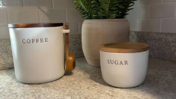 Three white containers with labels on a kitchen counter.