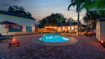 Relax by the pool surrounded by a brick border and a warm fire feature.
