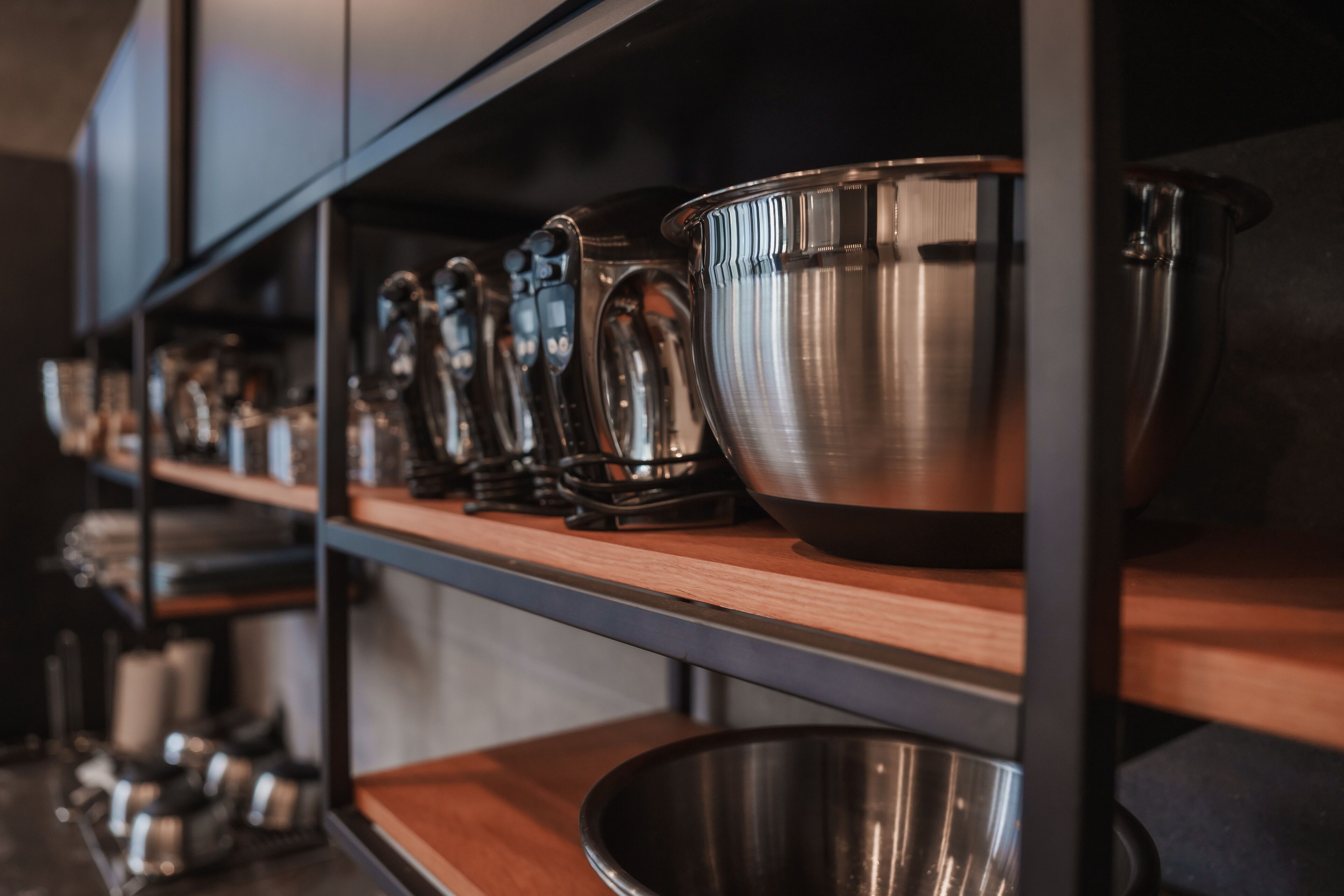 Una cocina con electrodomésticos de acero inoxidable y estanterías de madera.