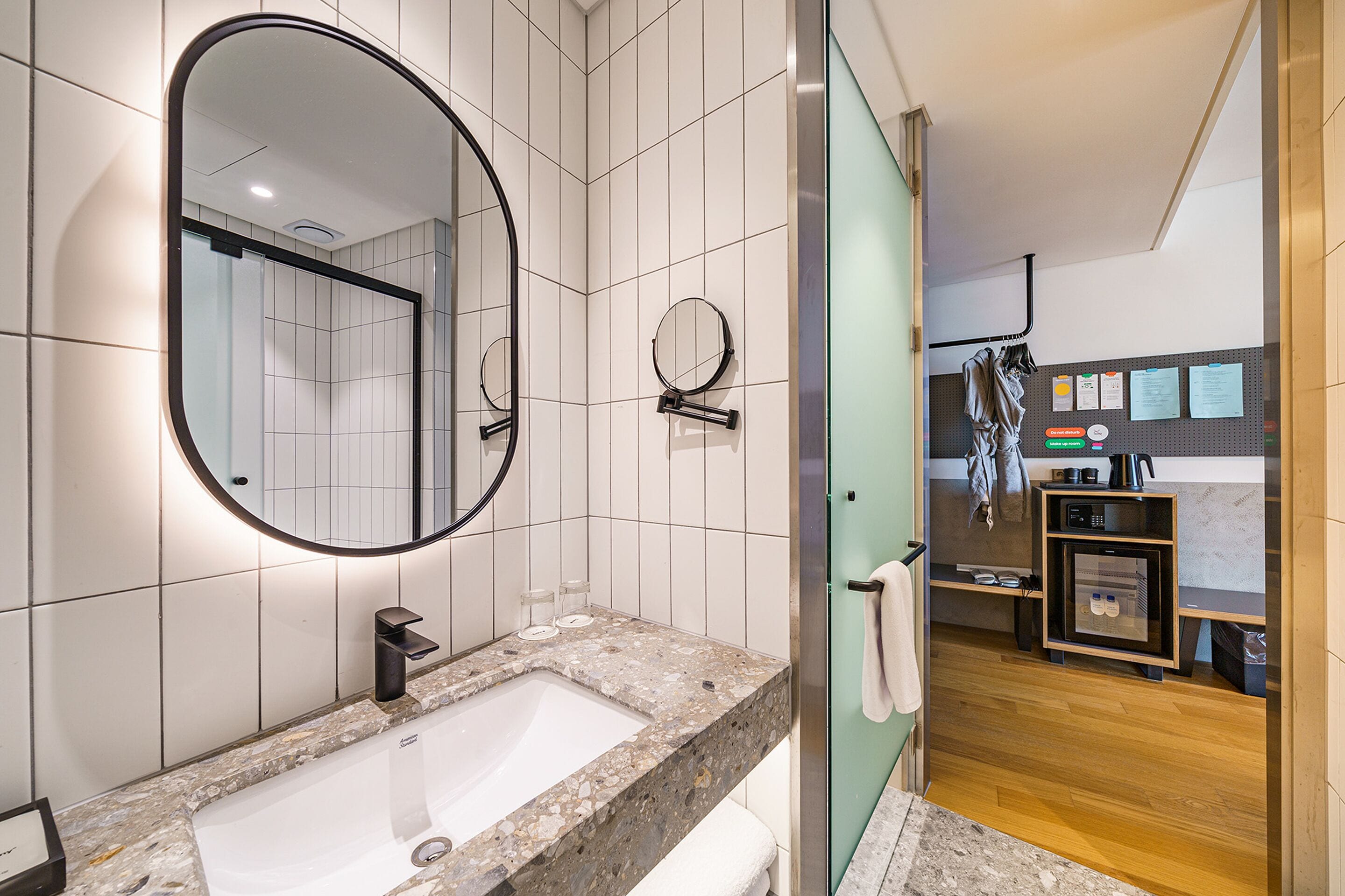 Un baño moderno con un espejo grande, un lavabo y una cabina de ducha de vidrio.