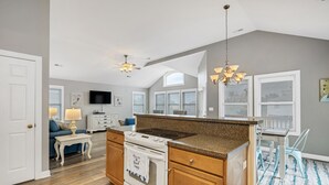 A modern kitchen with a central island, wooden cabinets, and a built-in oven.