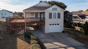 A single-story house with a front porch, a garage, and a small deck.
