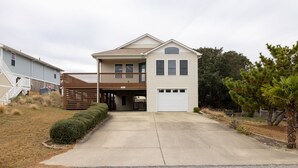 A two-story house with a garage, a covered porch, and a small front yard.