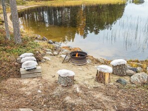 Un camping frente al lago, con un hoyo para la fogata, asientos de piedra y vistas despejadas del agua.