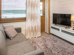 A living room with a sofa, a television, and a fluffy rug.