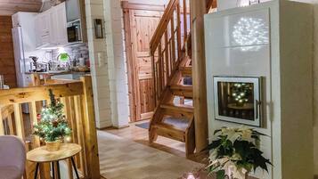 Un intérieur chaleureux avec un escalier en bois, un coin repas agrémenté d’un petit sapin de Noël et une cuisine équipée d’appareils modernes.