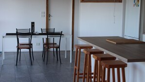Eine moderne Küche mit Esstisch und vier hölzernen Hocker.