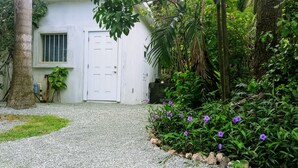 A white building with a gravel driveway leading to a door. - The Boat Shed (Christiansted)