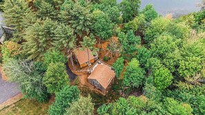 A cabin surrounded by dense forest, with a clear view of the surrounding trees.
