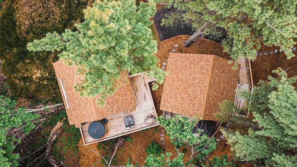 Een dakterras met houten terras, zitgedeelte en een kleine tafel.