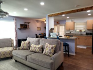 A living room with a sofa and a dining area in the background. - Condo Serenity (Harlingen)