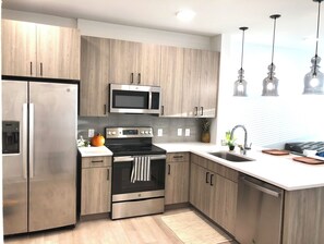 Enjoy cooking in this well-equipped kitchen with stainless steel appliances, a kitchen island, and a sink with modern faucet.