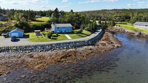 A residential area with a house, a dock, and a river. - Tangier Oceanfront Escape with Hot Tub, Sauna & Kayaks (Tangier)