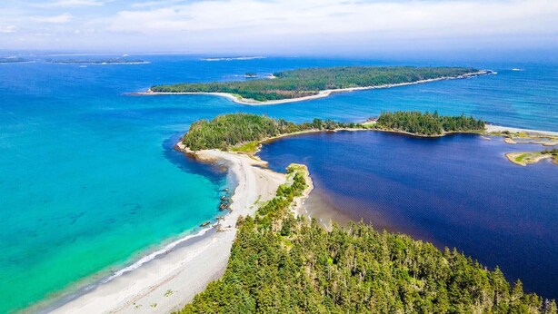An aerial view of a coastal area with clear blue waters, sandy beaches, and dense forests. - Tangier Oceanfront Escape with Hot Tub, Sauna & Kayaks (Tangier)