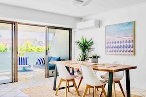 Enjoy a peaceful retreat with a sliding glass door leading to an outdoor area, a dining table, and a comfortable seating area.