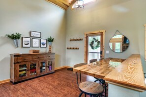 A dining area with a wooden table and chairs, a wooden cabinet with glass doors, and wall-mounted artwork.