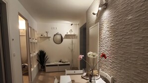 Un coin repas avec une table et des chaises, un miroir et un mur en briques.
