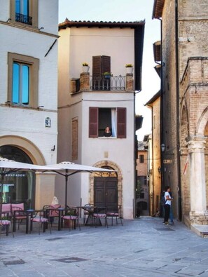 A narrow street with a café on the left, featuring outdoor seating and a visible storefront. - Delicious, Cozy Apartment in Montefalco (Montefalco)