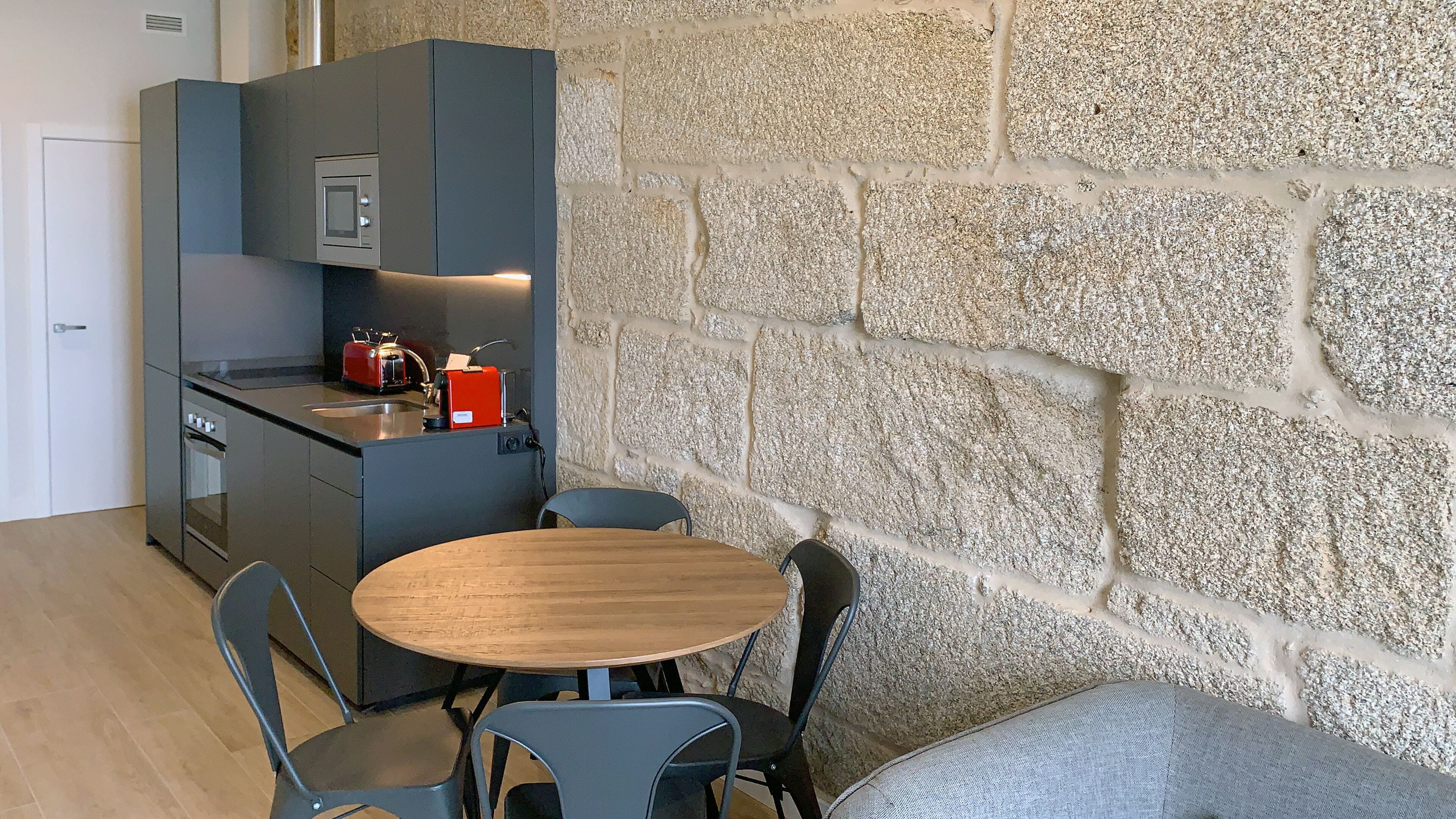Una cocina funcional con electrodomésticos modernos, una mesa de comedor y sillas.