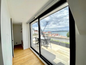 A room with a large sliding glass door leading to an outdoor patio with a table and chairs. - X Flats Taksim (Istanbul)