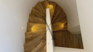 A modern spiral staircase with wooden steps and a white central column. - X Flats Taksim (Istanbul)