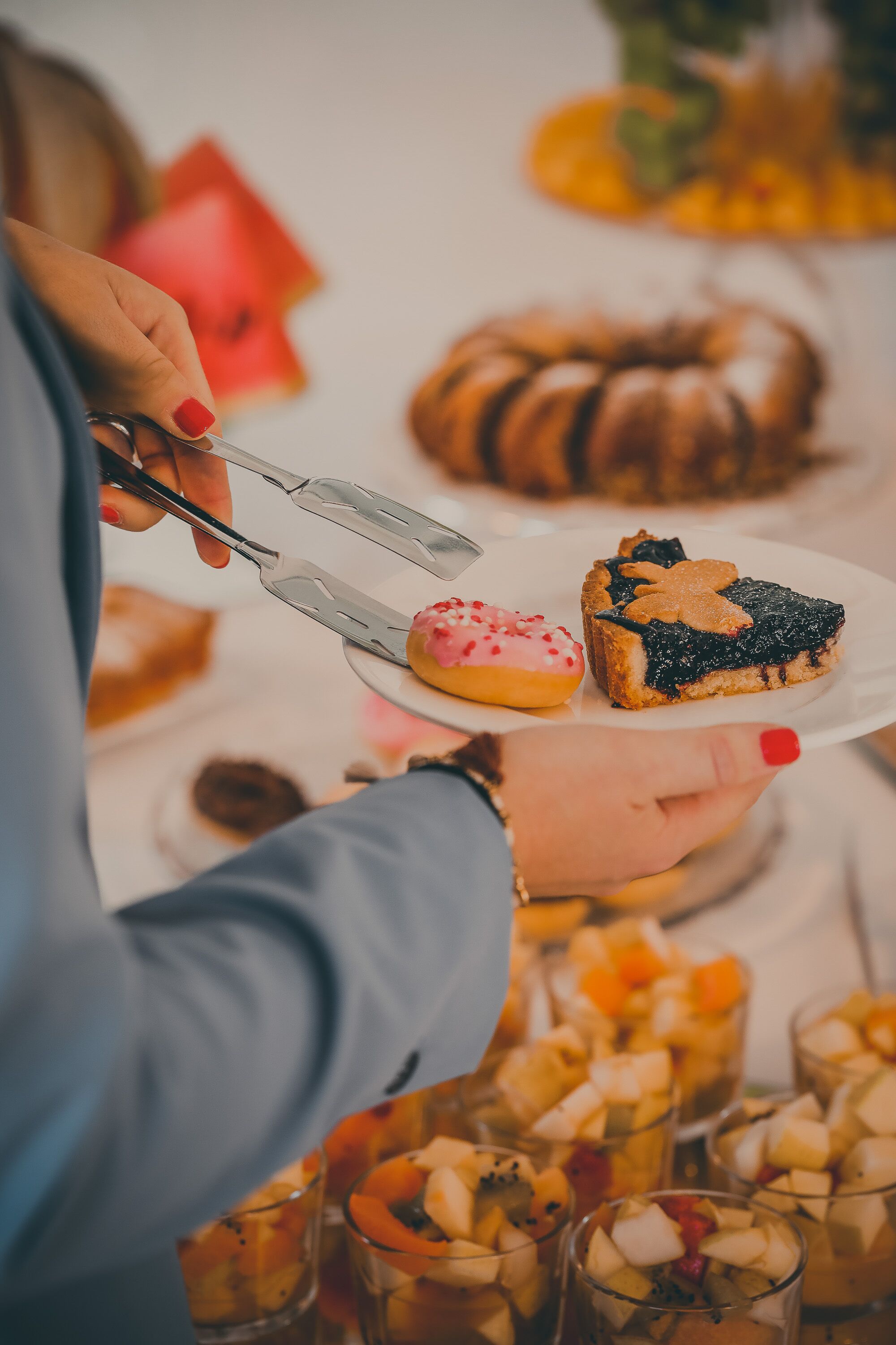 A person holding a plate with a slice of pie and a donut.