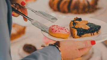 A person holding a plate with a slice of pie and a donut.